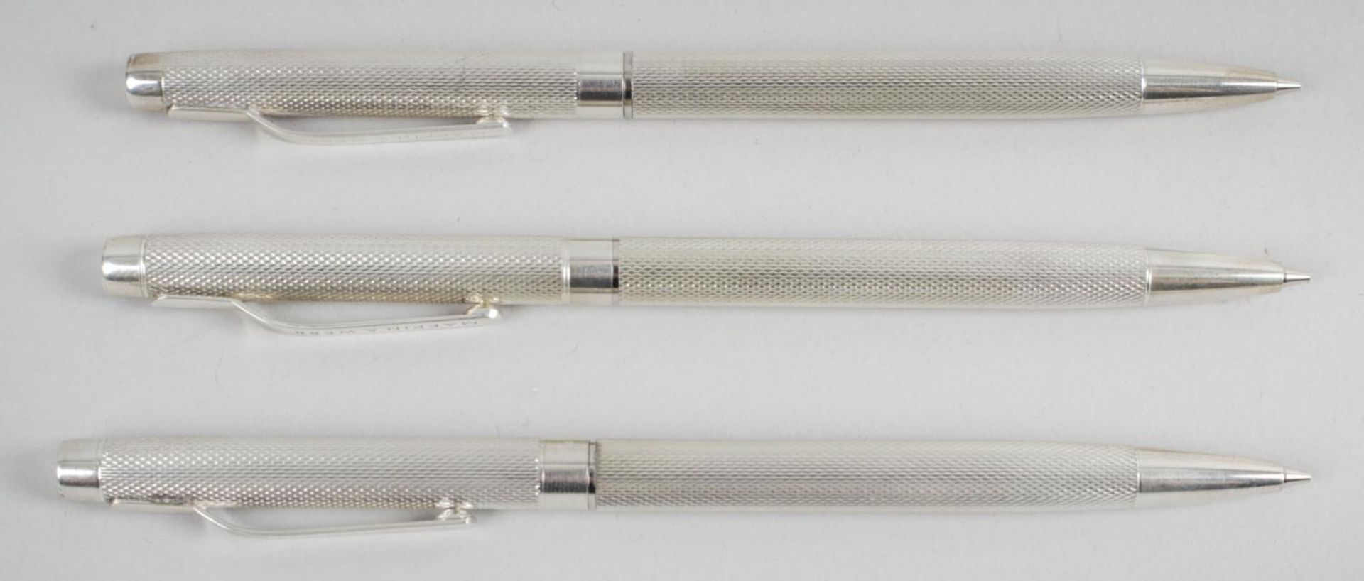 Three modern hallmarked silver cased propelling pencils,