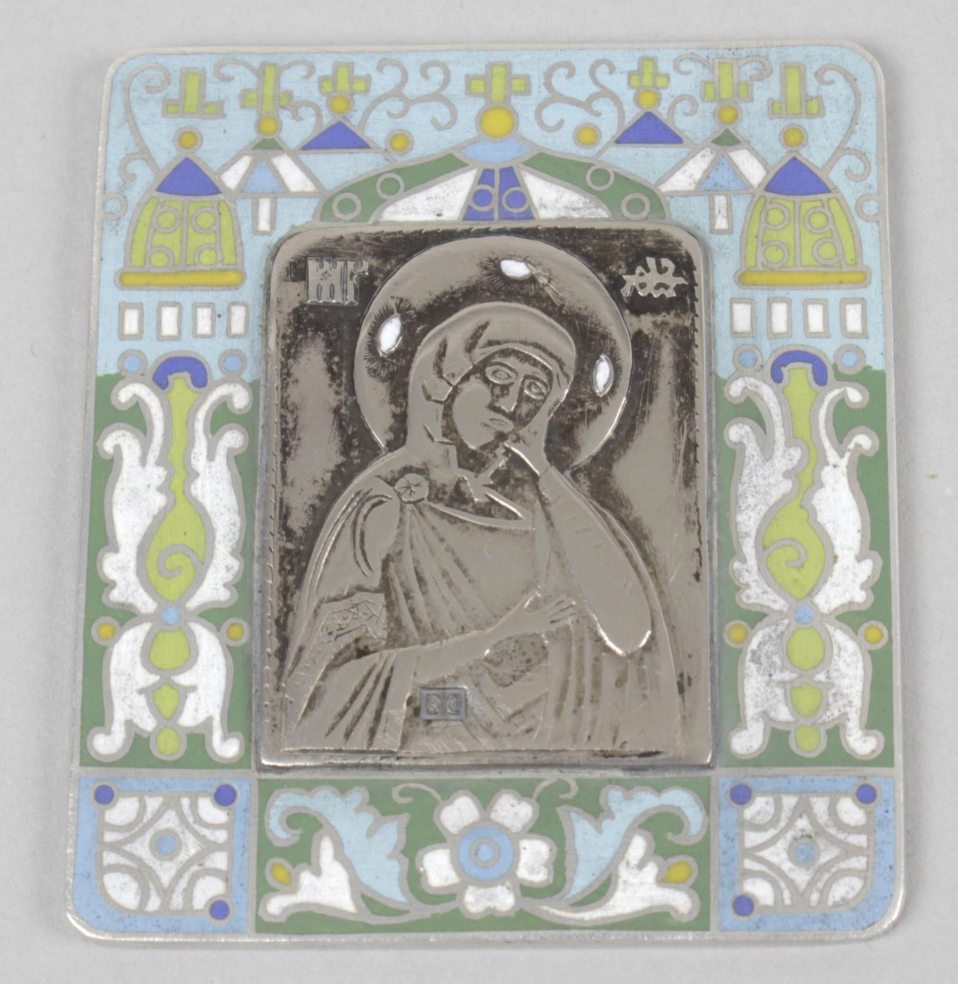 A small white metal religious picture or icon,