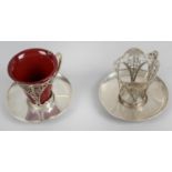 A pair of Art Nouveau silver coffee cup holders and saucers,