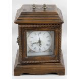 A stained wooden cased mantel clock with battery operated quartz mechanism,