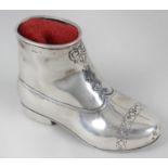 A late Victorian silver pin cushion, modelled as a boot with engraved laces and stitching detail.