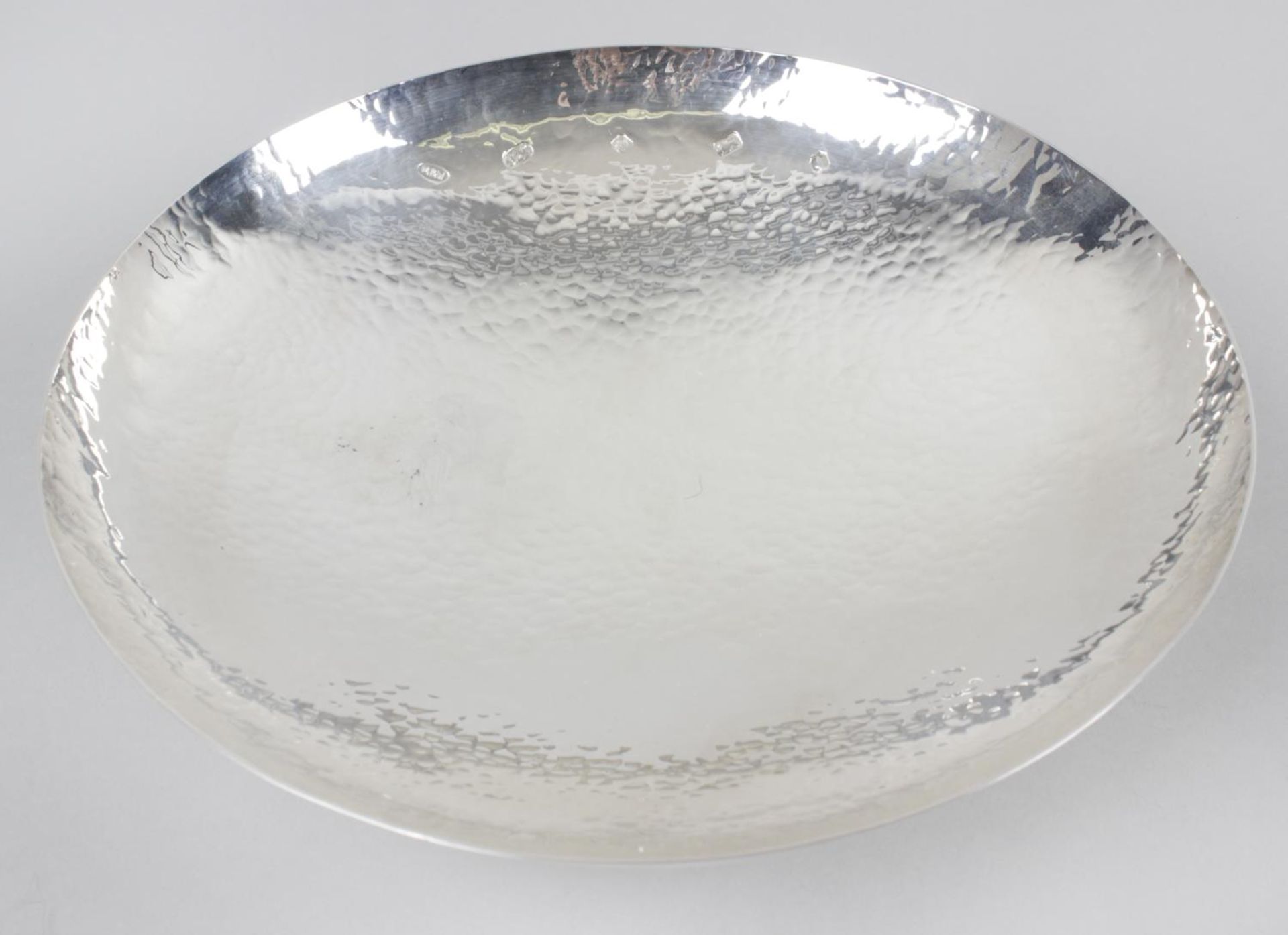 A cased modern silver dish, of circular footed form, with planished finish to the whole.