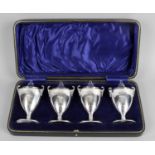 A cased set of four silver pepper pots,