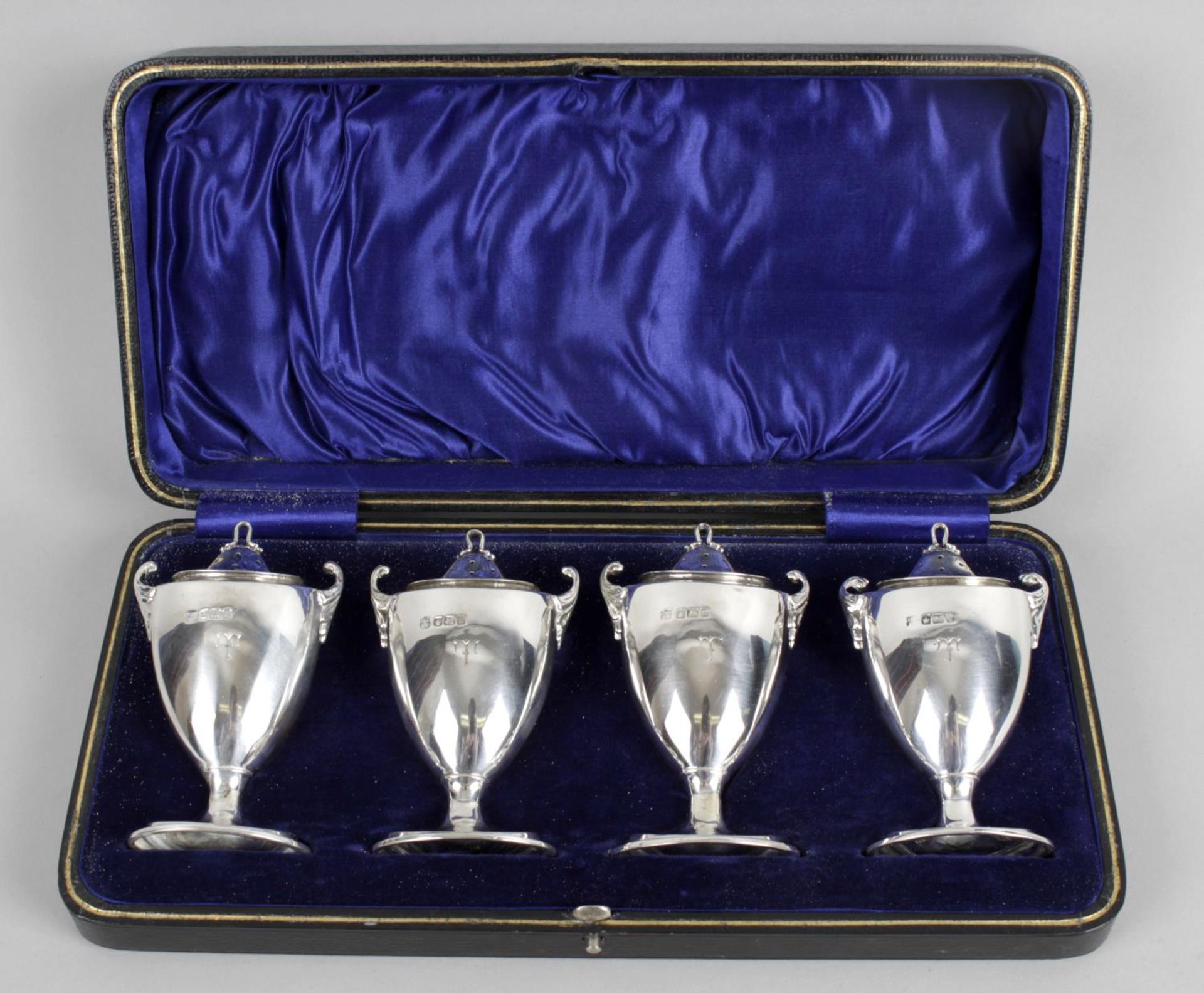 A cased set of four silver pepper pots,