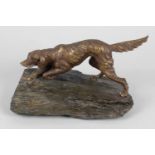 A cast metal bronzed figure modelled as a setter upon a natural slate base, 9.5 (24cm) wide.