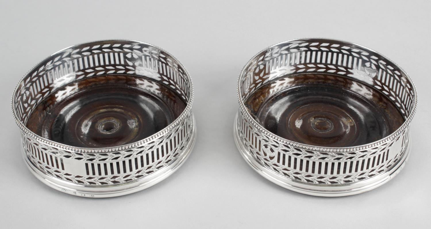 A pair of George III silver mounted wine coasters,