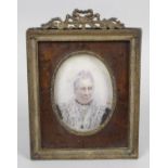 A late 19th century circular head and shoulder portrait miniature upon ivory panel depicting a