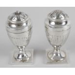 A pair of George III small silver casters,