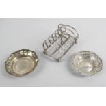 A small selection of silver items to include a seven bar toast rack raised on four ball feet,