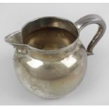 A modern silver cream jug, of plain bulbous form, the curved handle with heart shaped terminal.