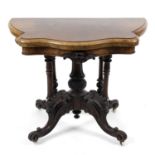 A Victorian walnut veneered fold over topped card table,