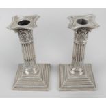 A pair of late Victorian silver mounted candlesticks,