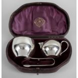 A cased Victorian silver set comprising a small cream jug and sugar bowl,