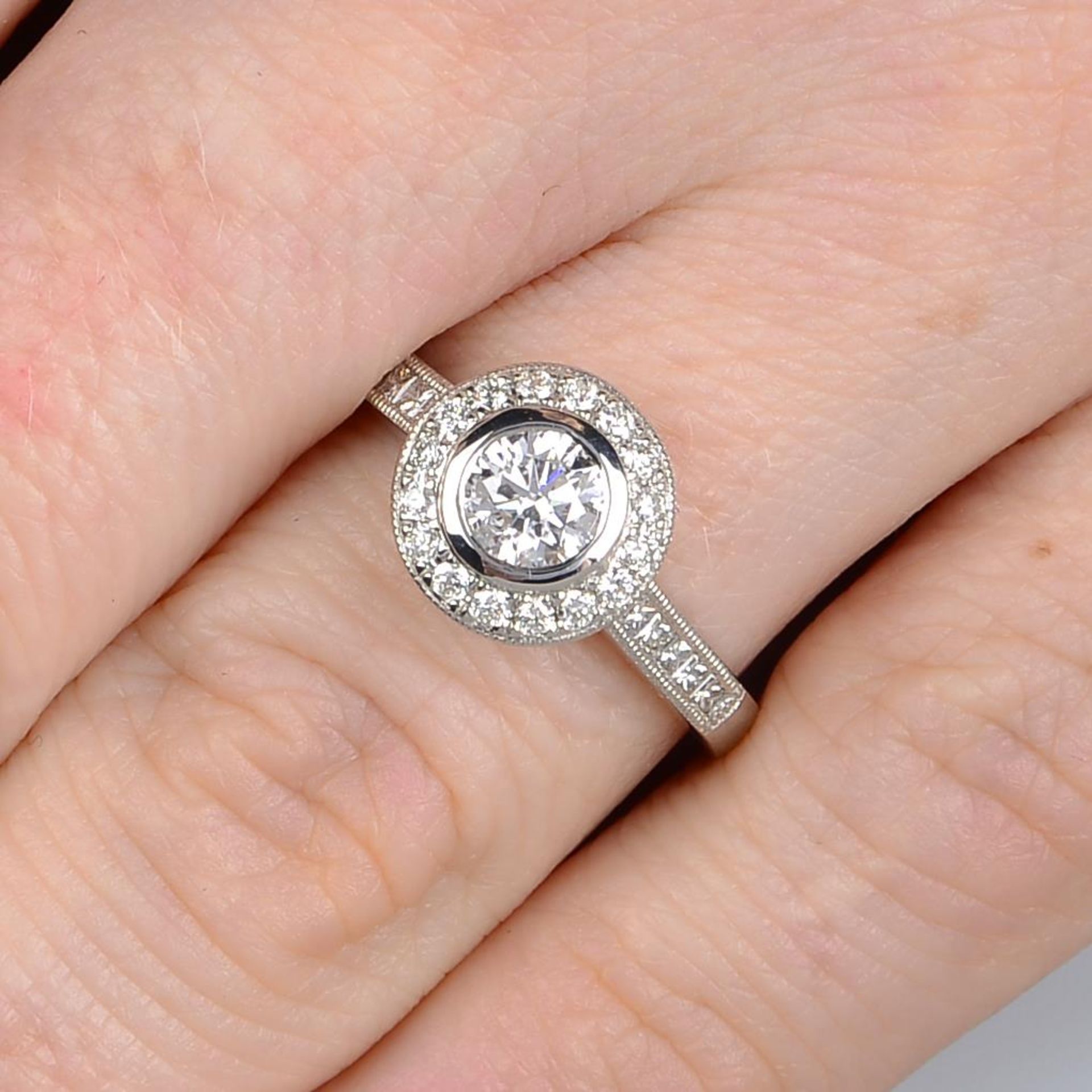 An 18ct gold brilliant-cut diamond cluster ring, with square-shape diamond line shoulders. - Bild 4 aus 5