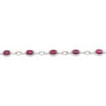 An 18ct gold ruby and brilliant-cut diamond cluster bracelet.Total ruby weight 5.14cts,