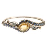 A late 19th century gold gem-set bangle.Gems include sapphire,