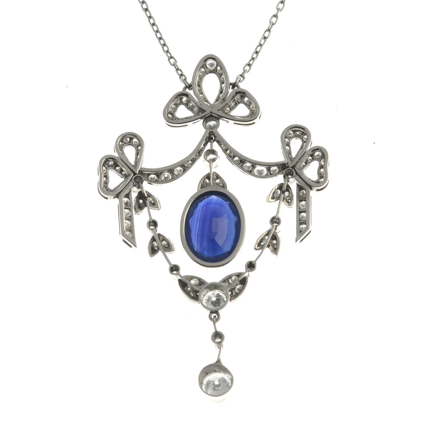A sapphire and diamond bow pendant, suspended from an integral trace-link chain. - Image 2 of 2