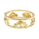 An 18ct gold bi-colour hinged bangle, designed as a carousel.