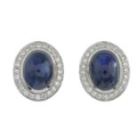 A pair of platinum sapphire cabochon and brilliant-cut diamond earrings.Total sapphire weight