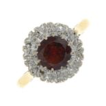 A garnet and diamond cluster ring.Estimated total diamond weight 0.25ct.Stamped 18ct.Ring size M.