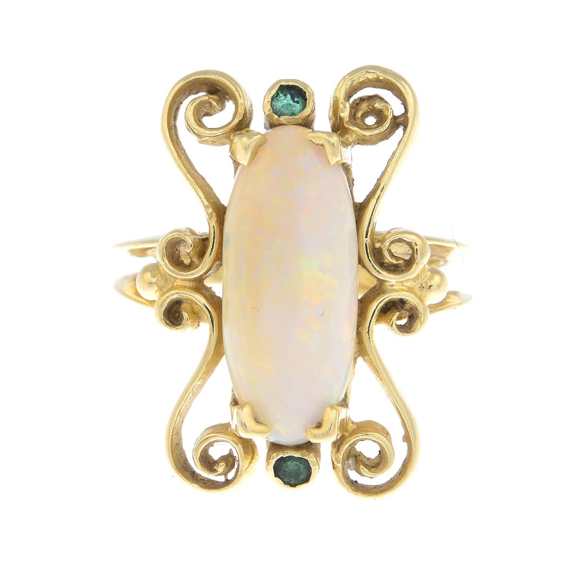 An opal and emerald dress ring.Approximate dimensions of opal 16.8 by 7 by 3.7mms.