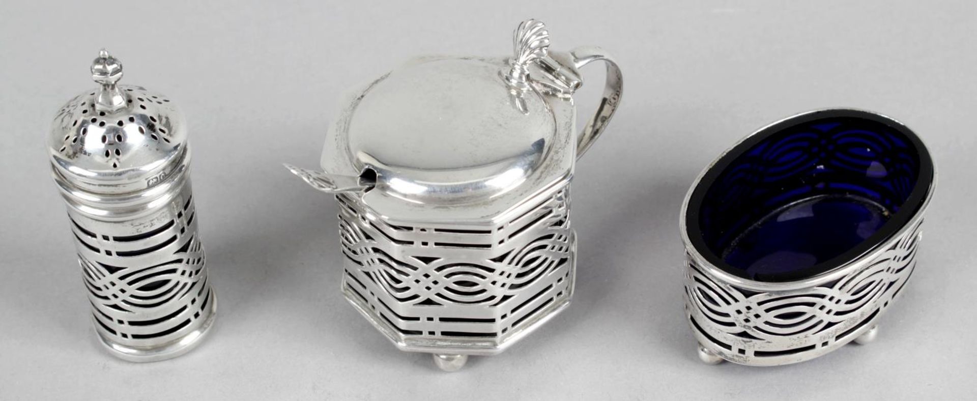 A matched silver three piece condiment set,