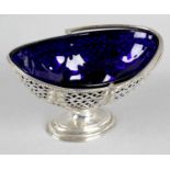 An Edwardian silver pedestal sugar basket with swing handle and blue glass liner,