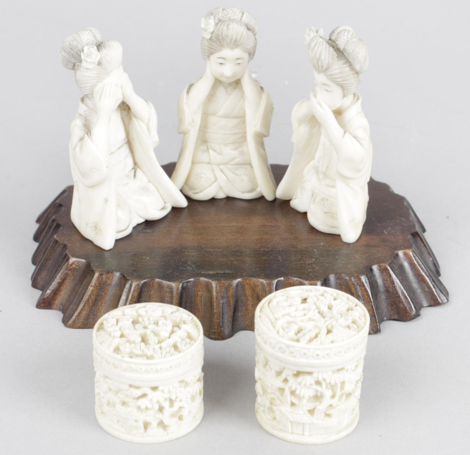 A late 19th century Oriental figure group modelled as three geisha girls each in kneeling-seated