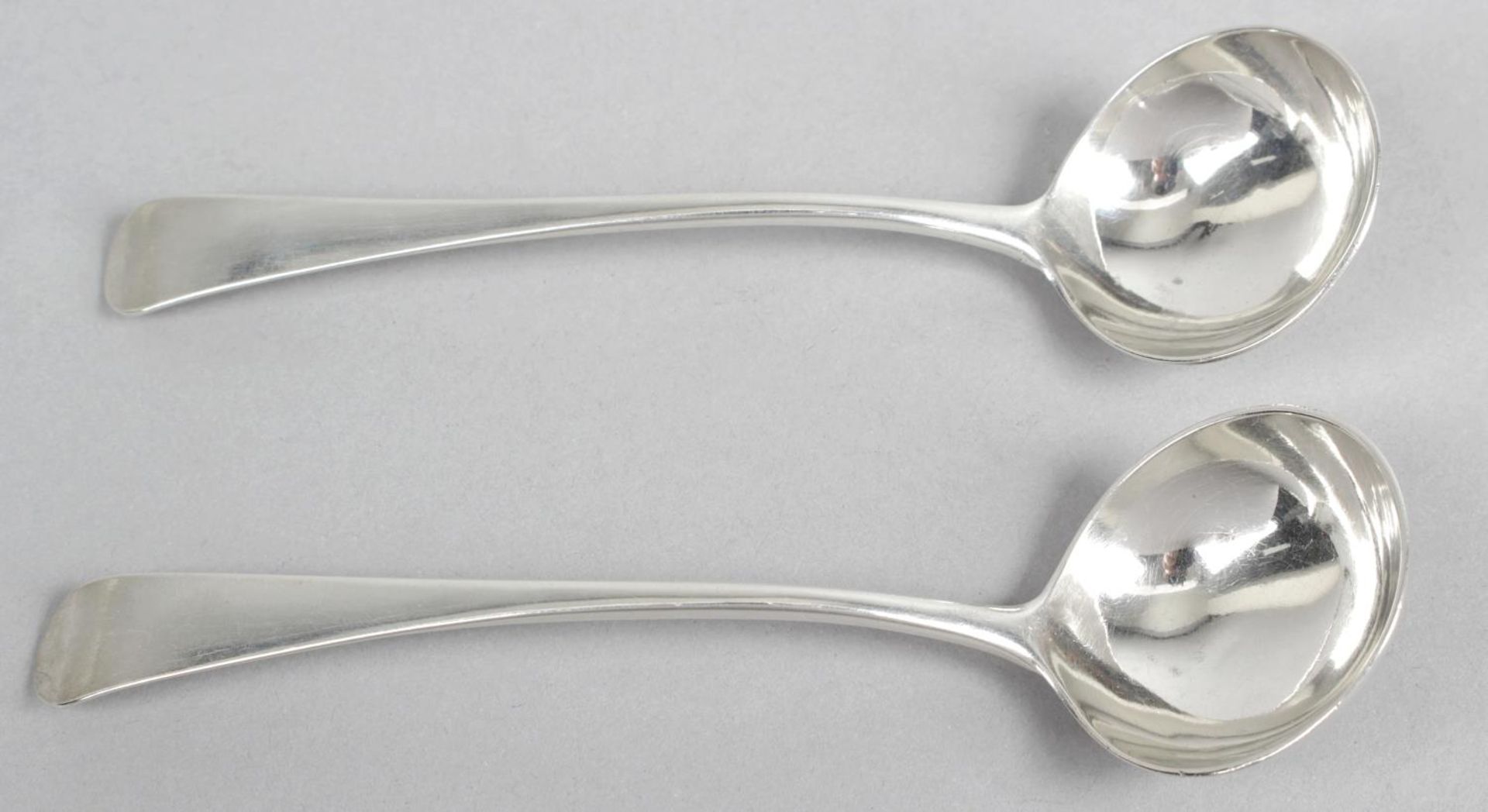 A pair of provincial silver toddy ladles, in Old English pattern with plain circular bowls.