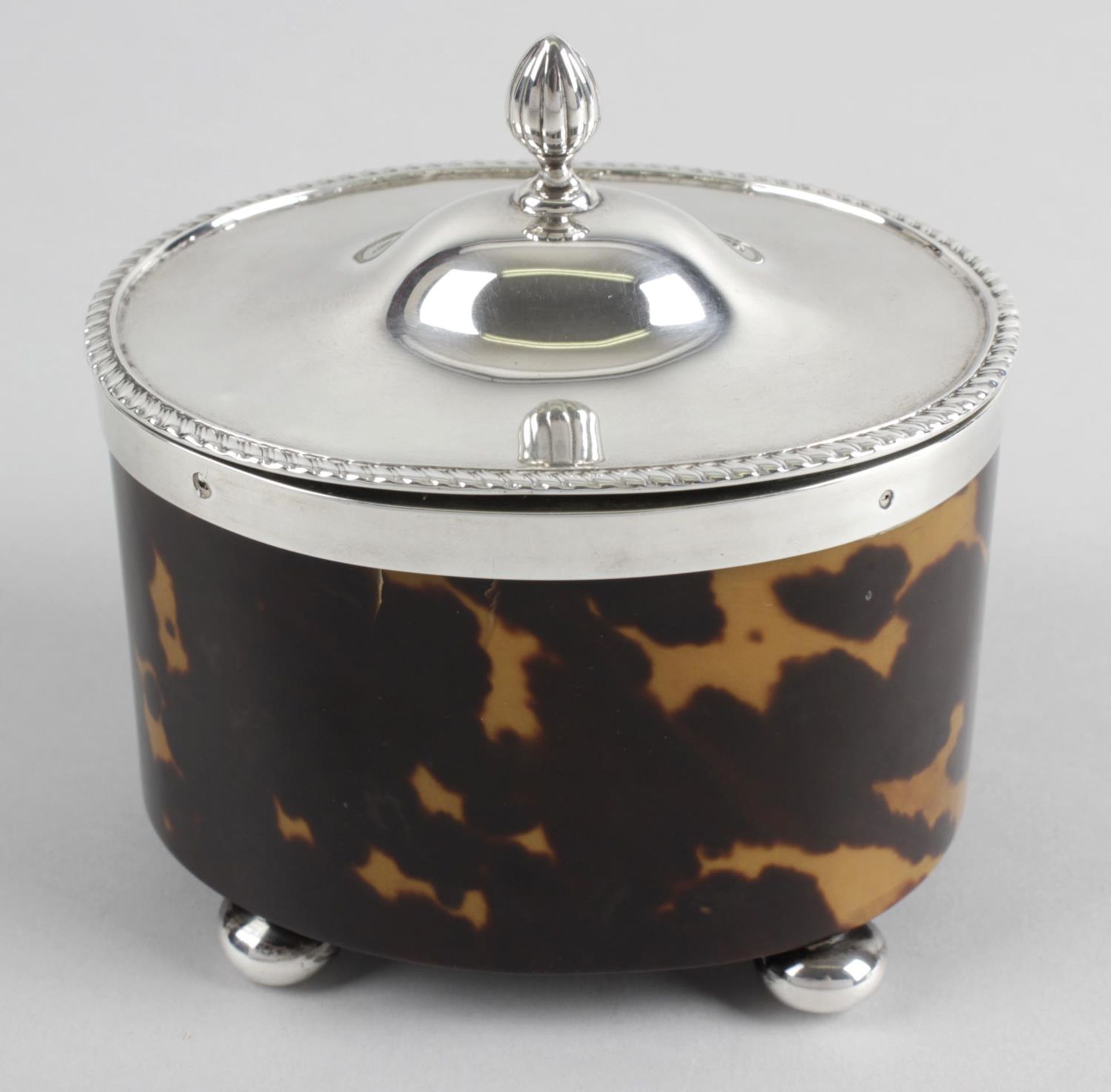 An Edwardian silver mounted and tortoiseshell veneer tea caddy of oval form,