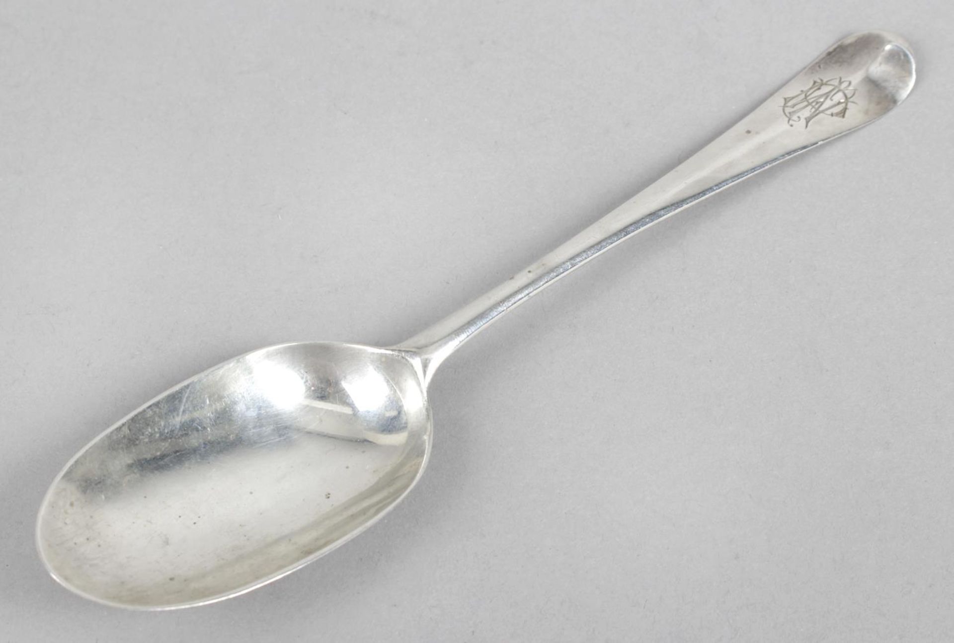 A George I Britannia silver spoon in Hanoverian pattern with long rat-tail to heel and monogram