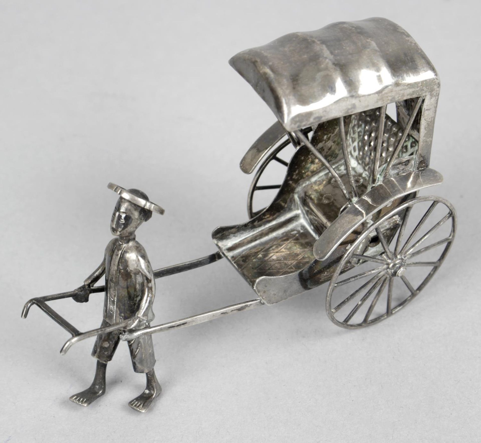 A Chinese export silver figure of a man pulling a rickshaw,