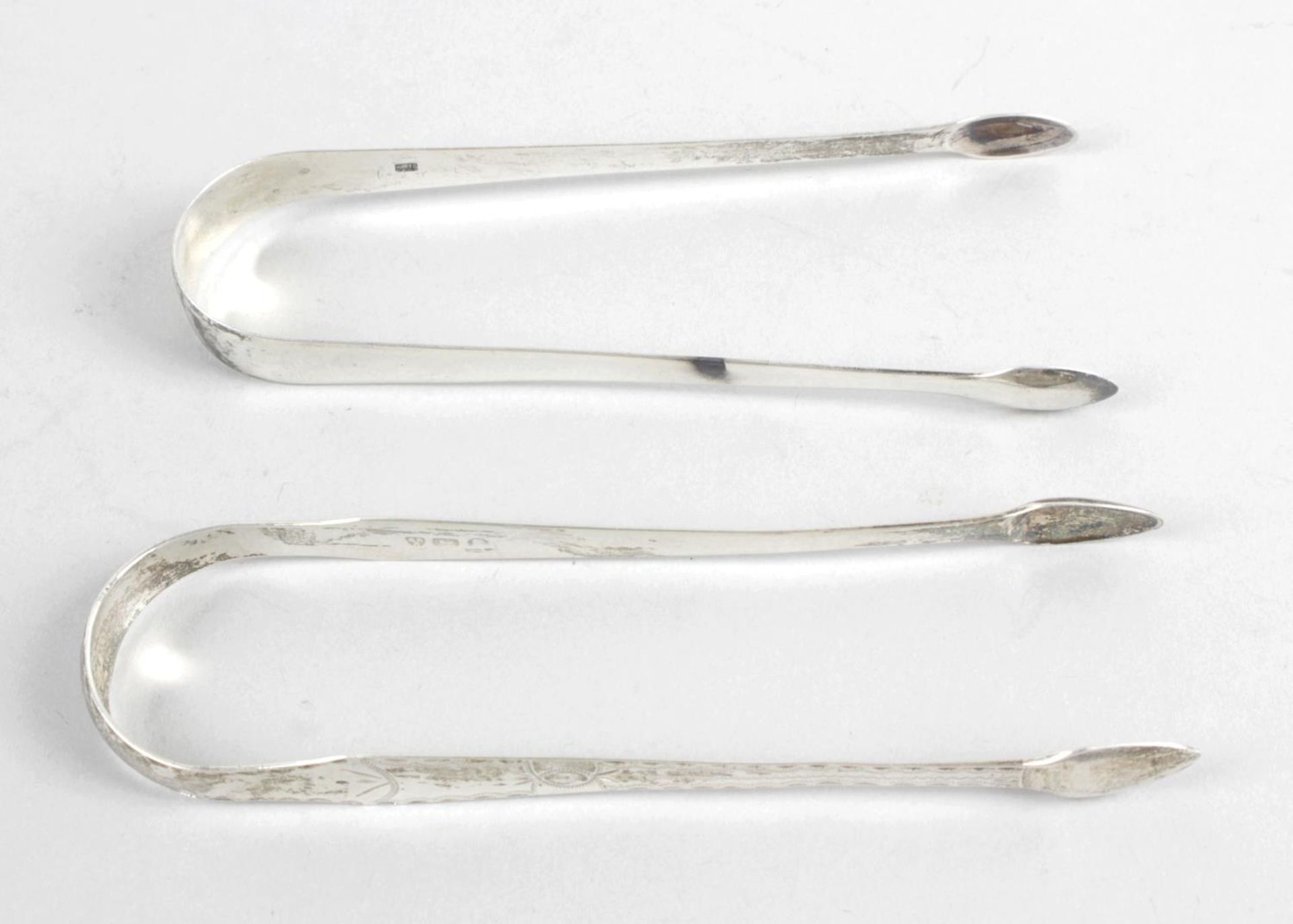 Two pairs of George III silver sugar tongs,