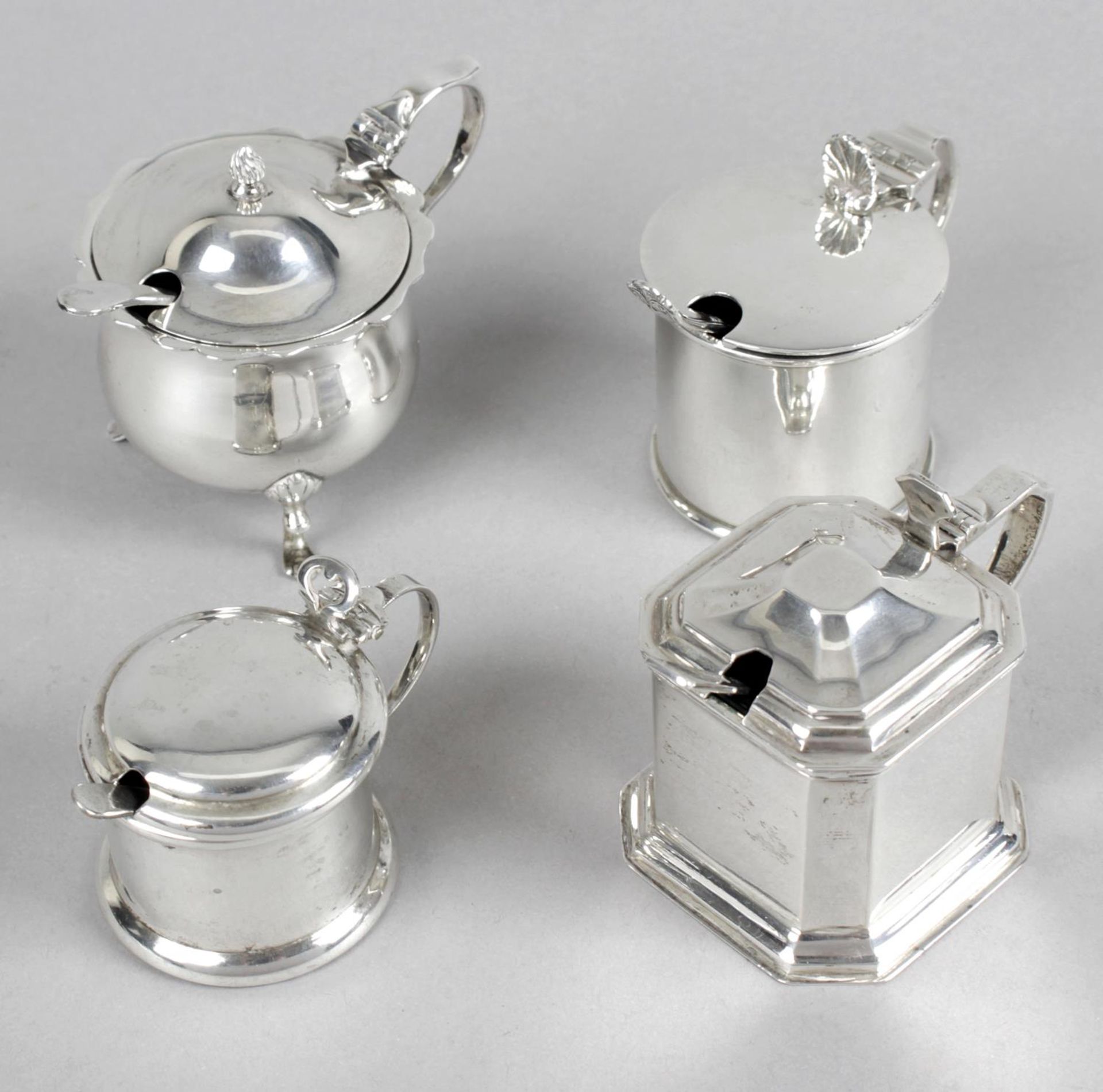 An Edwardian silver mustard pot of plain drum form with shell thumb-piece,