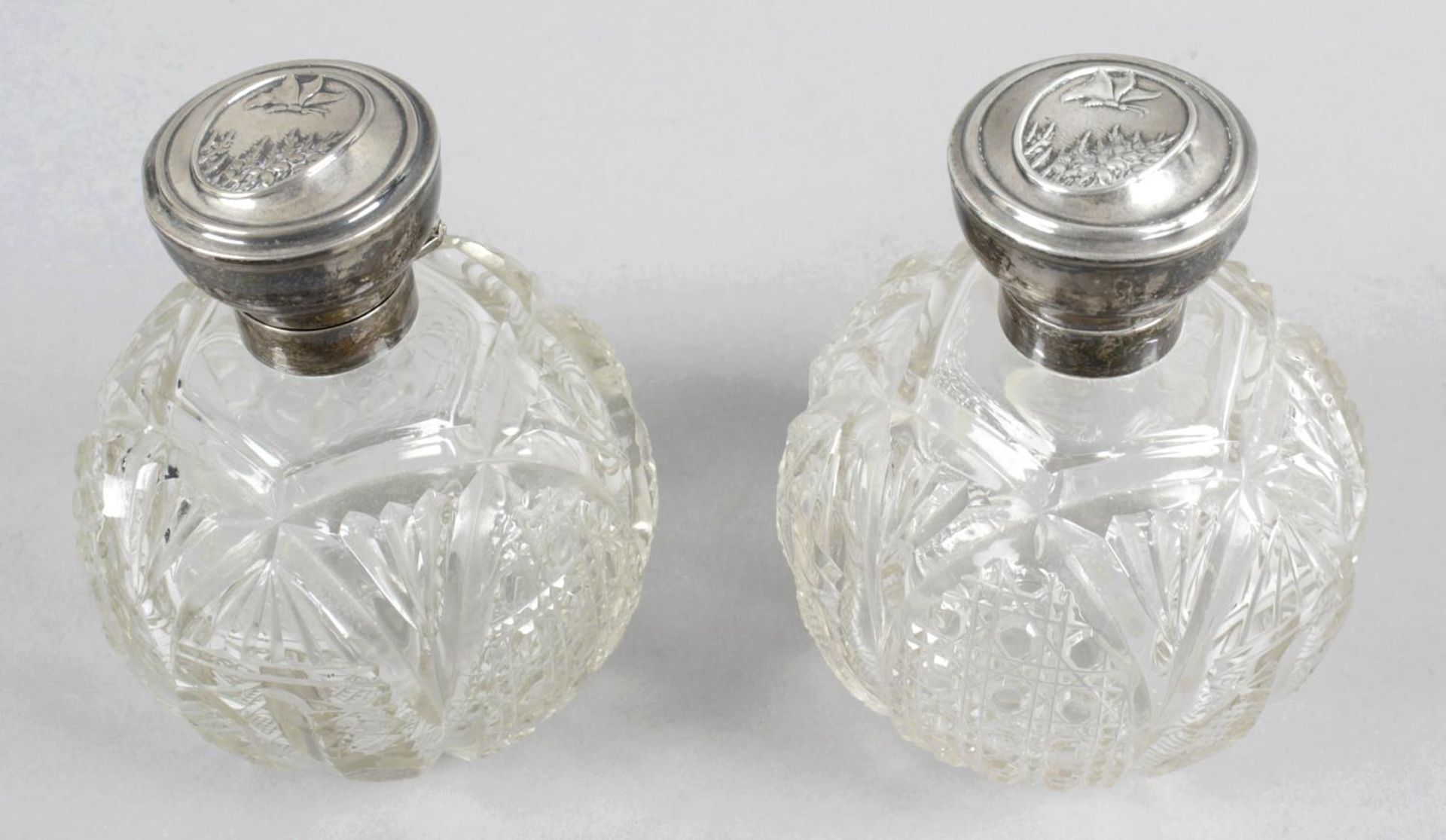 A pair of 1920's silver mounted and glass perfume bottles,