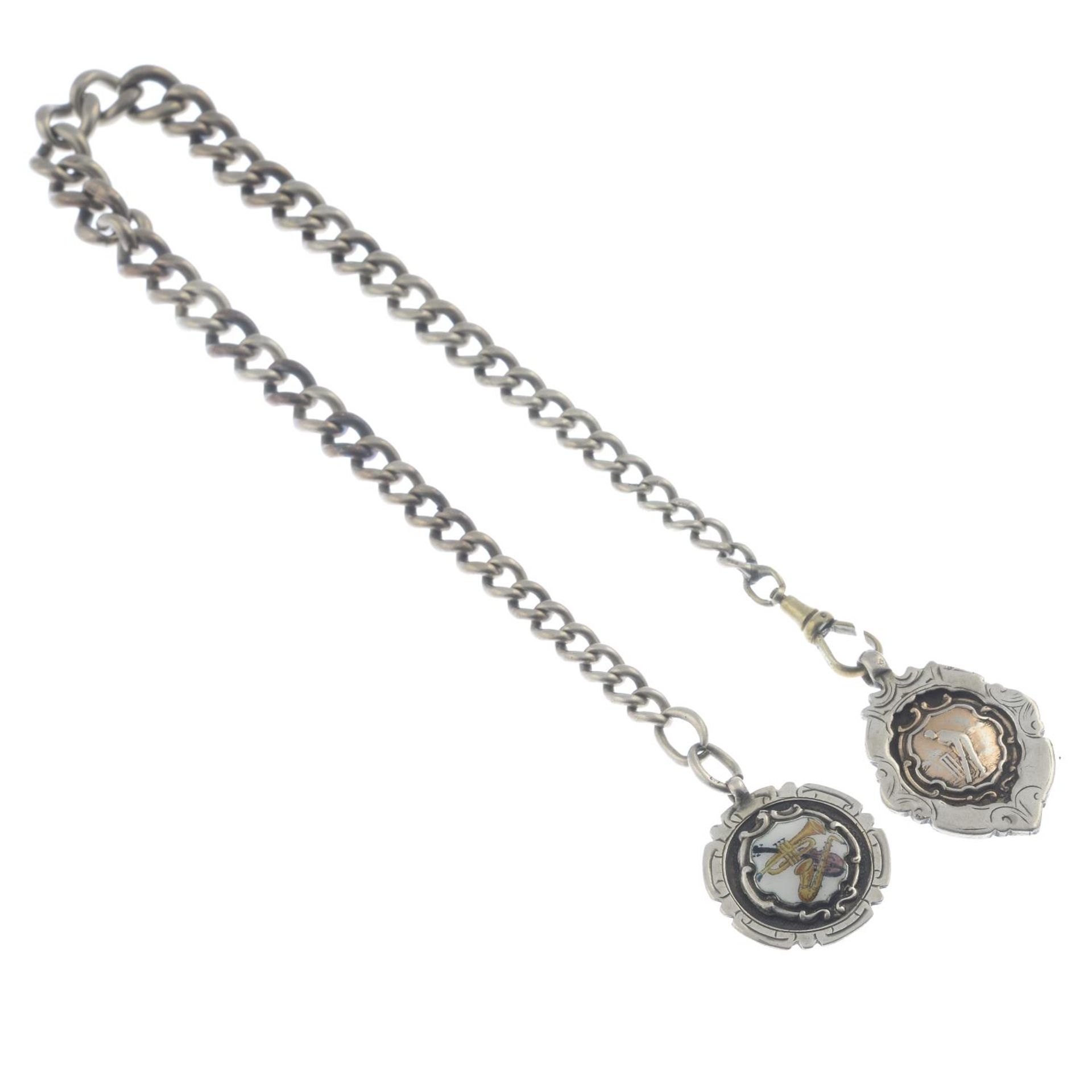 A Victorian silver albert chain and two fobs.