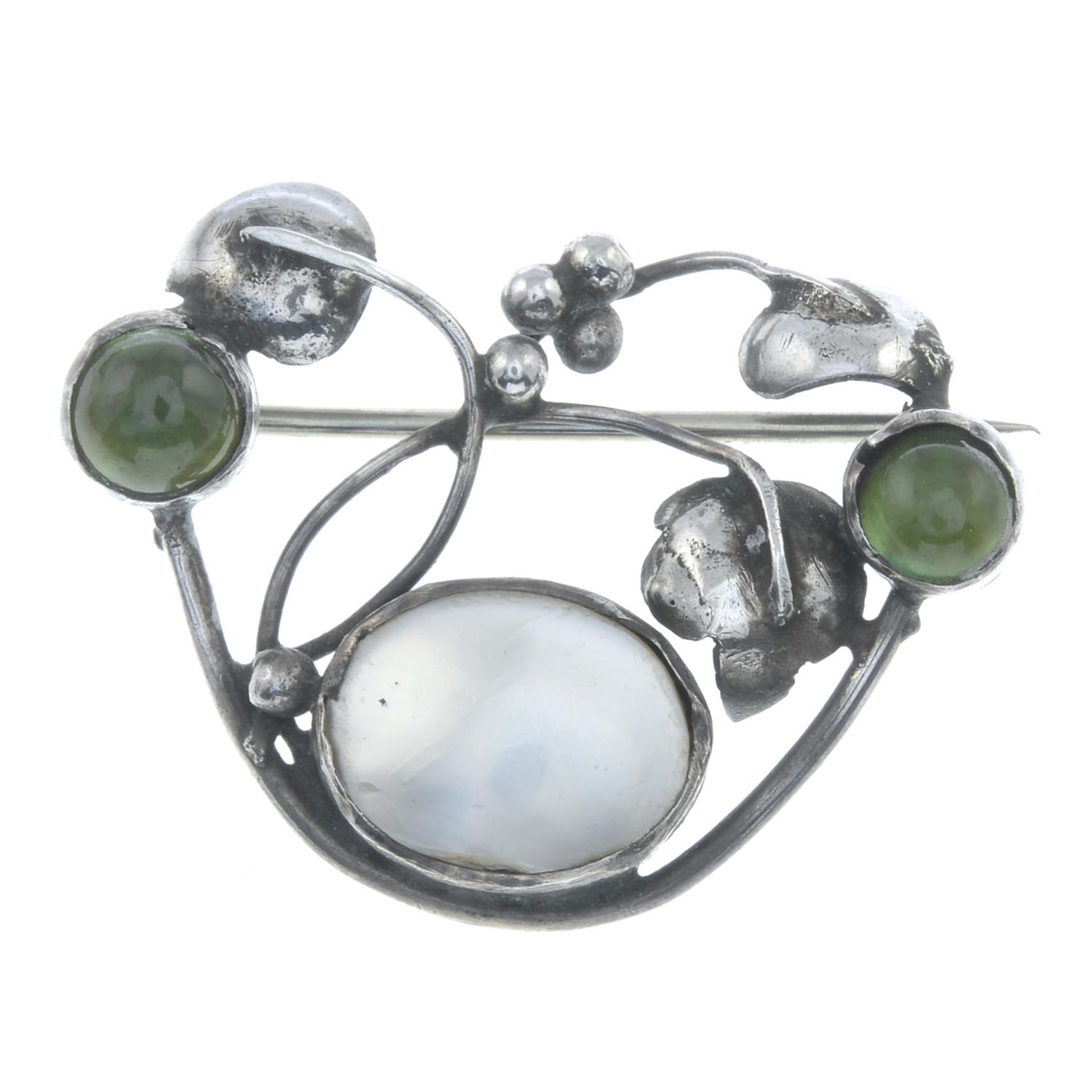 An Arts and Crafts silver mother-of-pearl and peridot cabochon brooch.Length 3.4cms.
