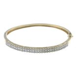 A diamond hinged bangle.Estimated total diamond weight 0.60ct.Stamped 375.Inner diameter 6.3cms.