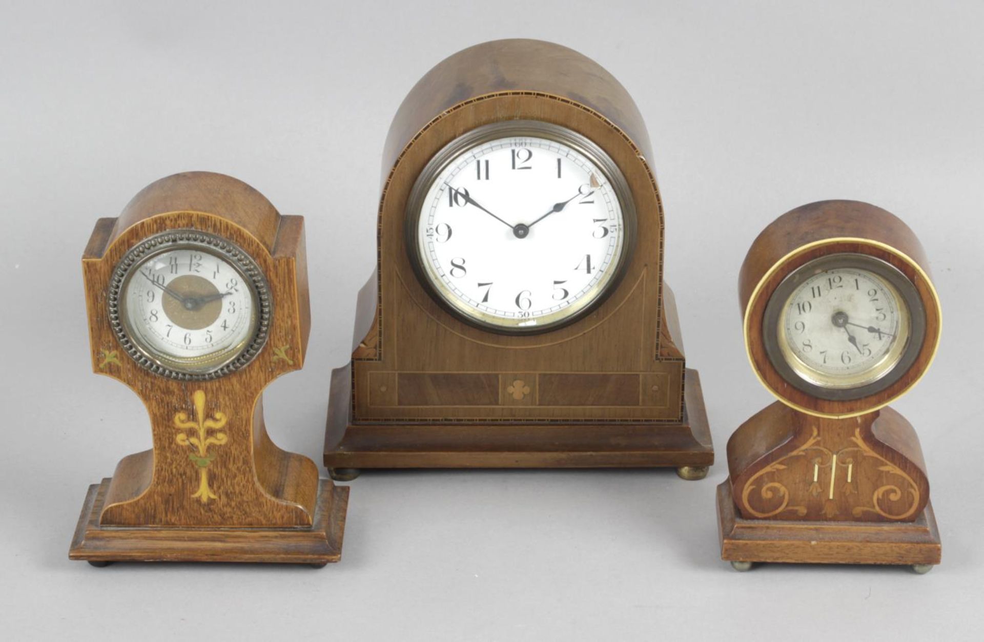 Four Edwardian mantel clocks, each with inlaid decoration to cases, the largest 9 (23cm) tall.