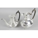 Two early 20th century silver hot water jugs - one of round bulbous plain form with swan neck spout