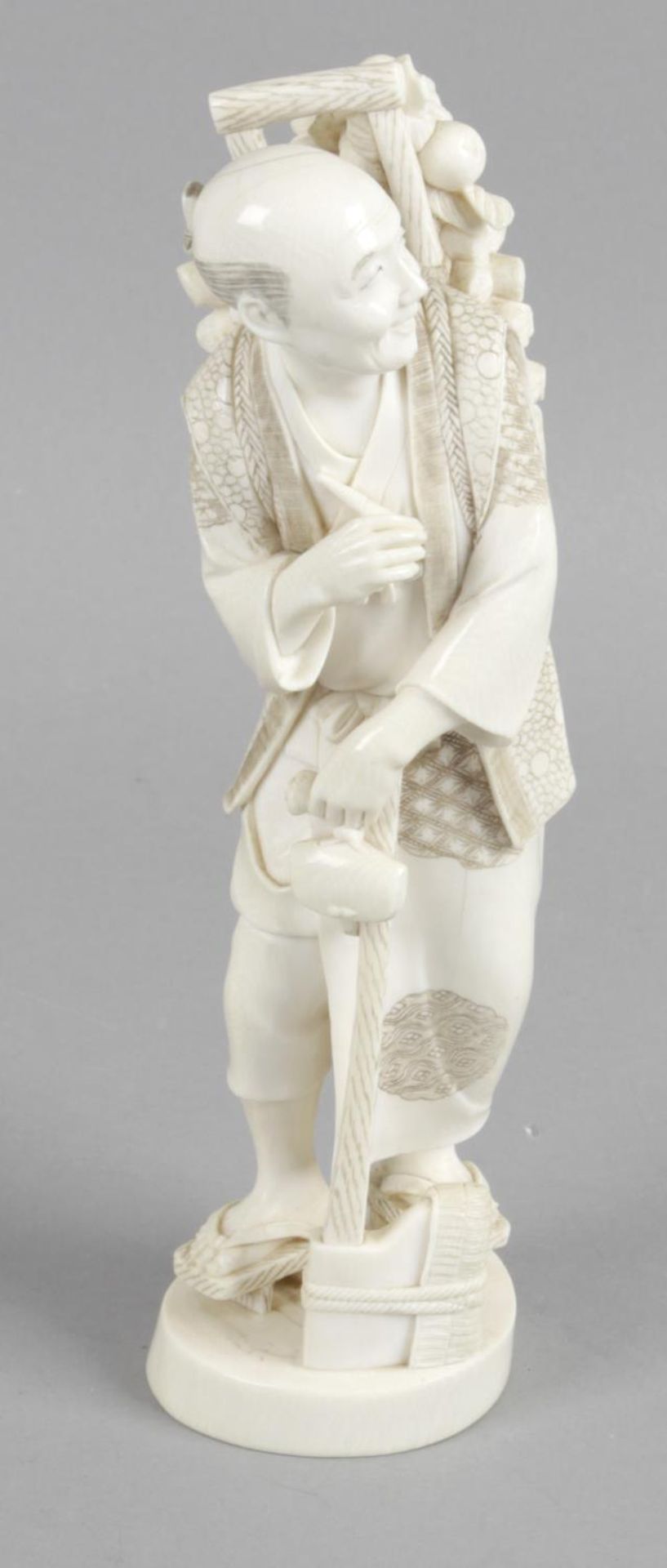 A late 19th century ivory okimono modelled as an elderly gentleman,