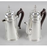 A pair of Queen Anne style silver coffee pot and hot water jugs with dome top lids and outward