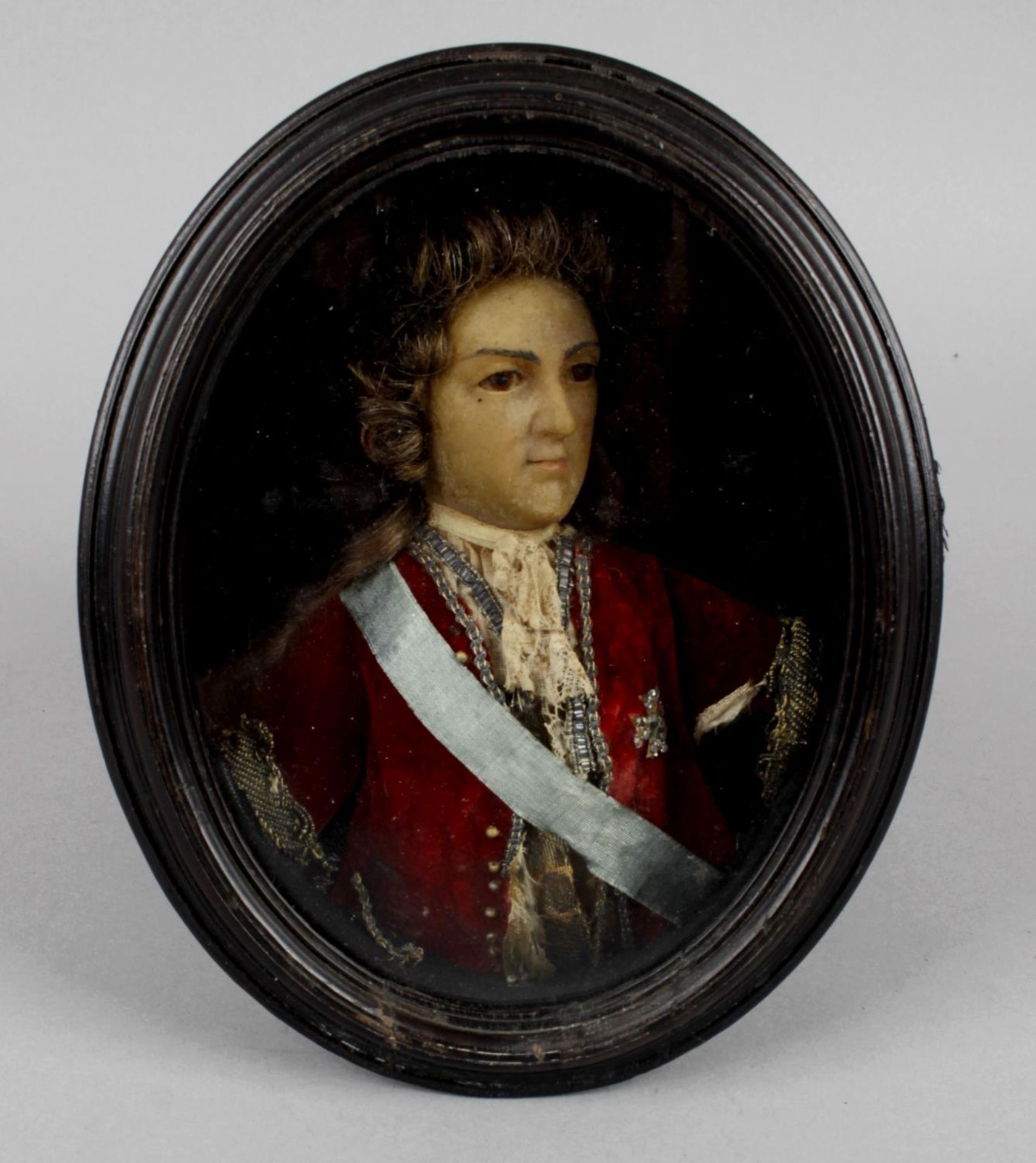 An antique painted wax oval half-length portrait depicting Louis XV,