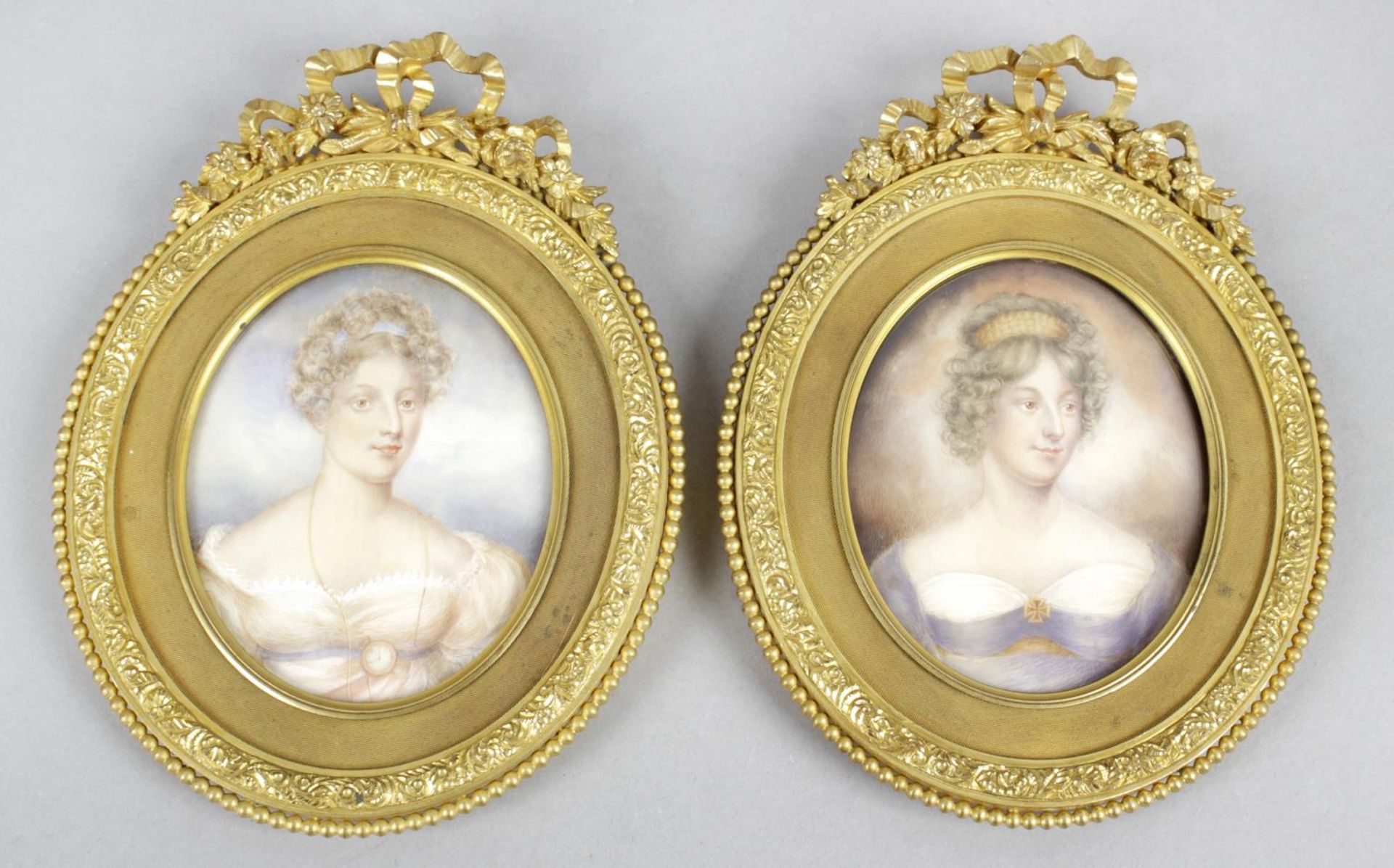 A pair of 19th century oval painted portrait miniatures upon ivory panels,