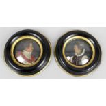 A pair of antique painted wax circular head and shoulder portrait miniatures,