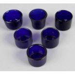A miscellaneous lot comprising twenty nine blue glass salt liners of various shapes and sizes,