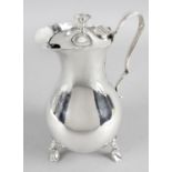 An Edwardian silver hot water jug of plain bulbous form with shaped handle and standing on three