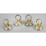 A set of four early George V silver mounted horse shoe menu or place name holders,