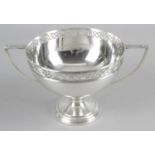 An early twentieth century silver twin-handled cup with pierced floral rim standing on a plain
