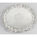 A Victorian silver round salver with shaped rim and decorative acanthus motifs,